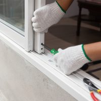 Construction worker repairing the sliding window.