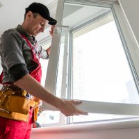 Cheerful young man mounting a kitchen window. High quality photo